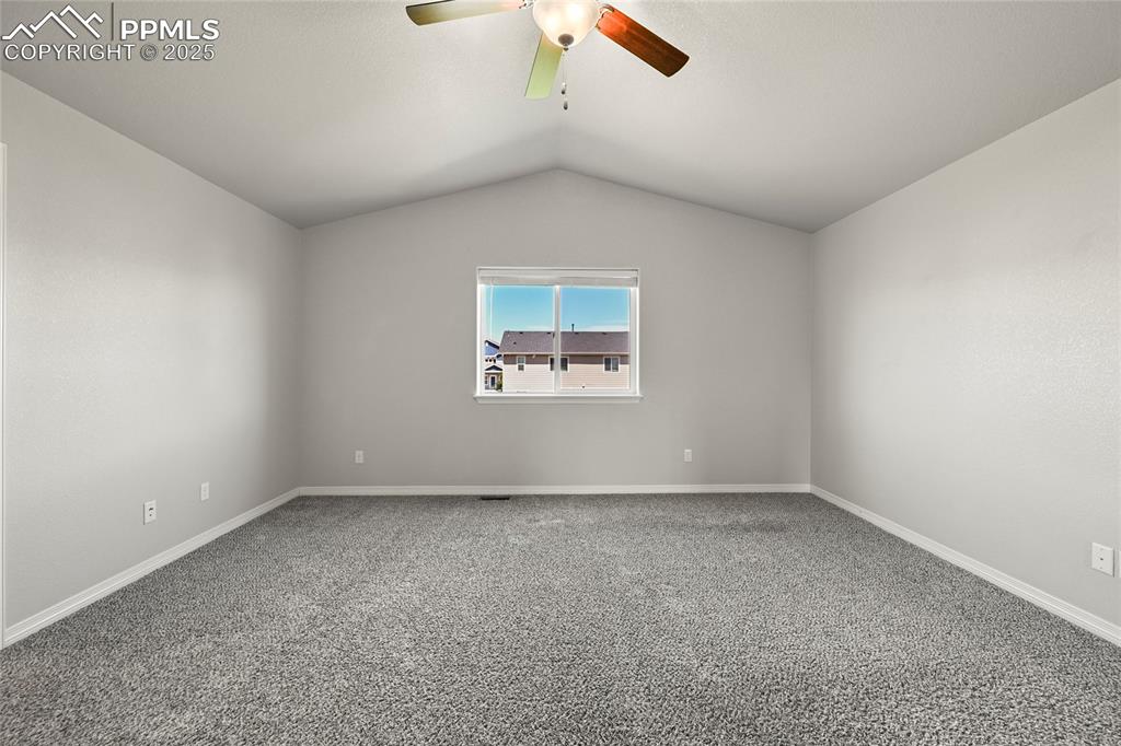 Image 17 of 29: Unfurnished room with lofted ceiling, ceiling fan, and carpet flooring