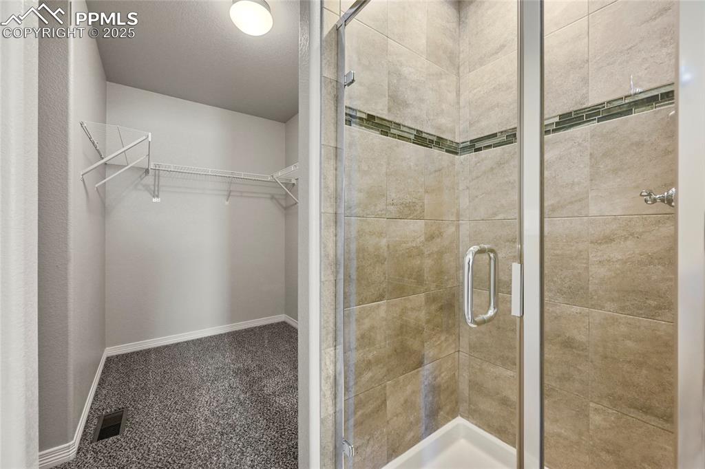 Image 19 of 29: Full bath featuring a shower stall and a walk in closet
