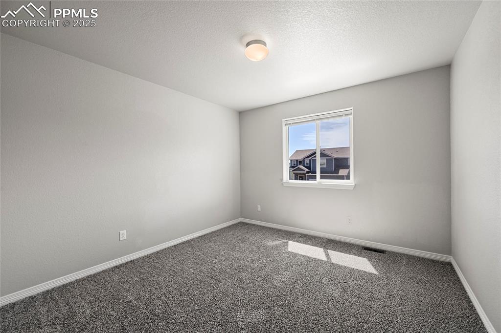 Image 23 of 29: Empty room featuring carpet floors and a textured ceiling