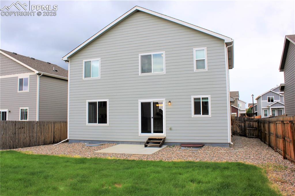 Image 27 of 29: Rear view of house with entry steps, a fenced backyard, and a patio