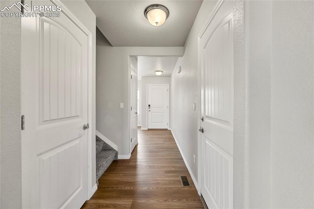 Image 6 of 29: Corridor featuring dark wood finished floors and a textured ceiling