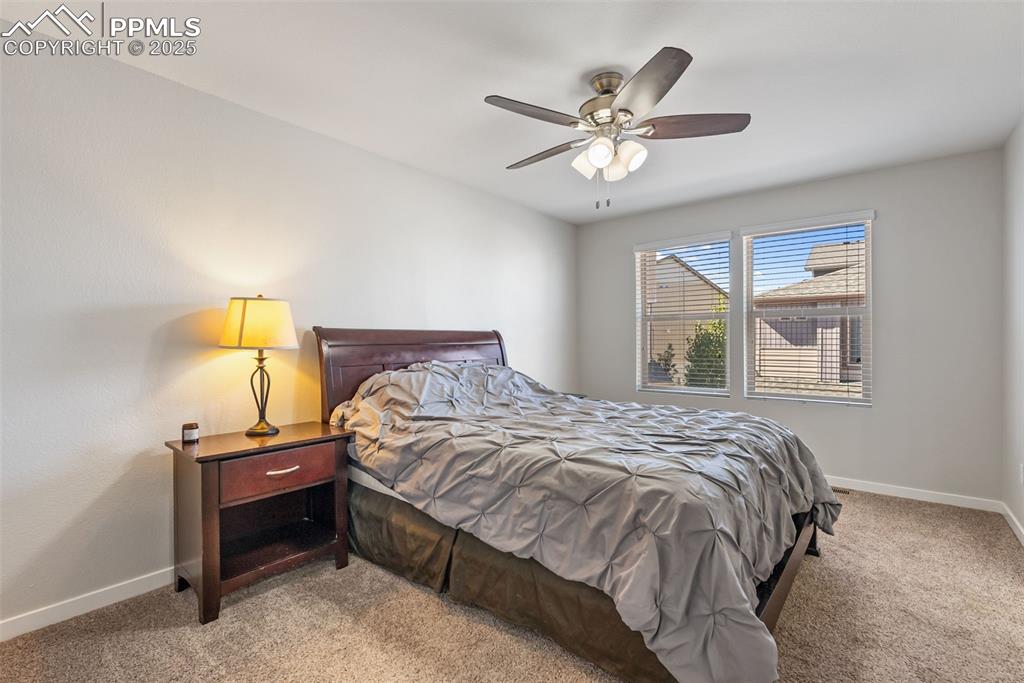 Image 16 of 50: Carpeted bedroom with baseboards and a ceiling fan