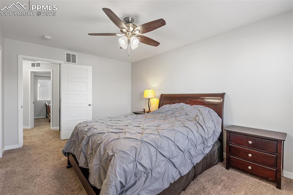 Image 17 of 50: Carpeted bedroom with baseboards and ceiling fan