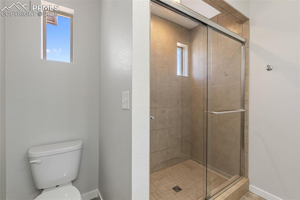 Image 20 of 50: Bathroom with a stall shower and a textured wall