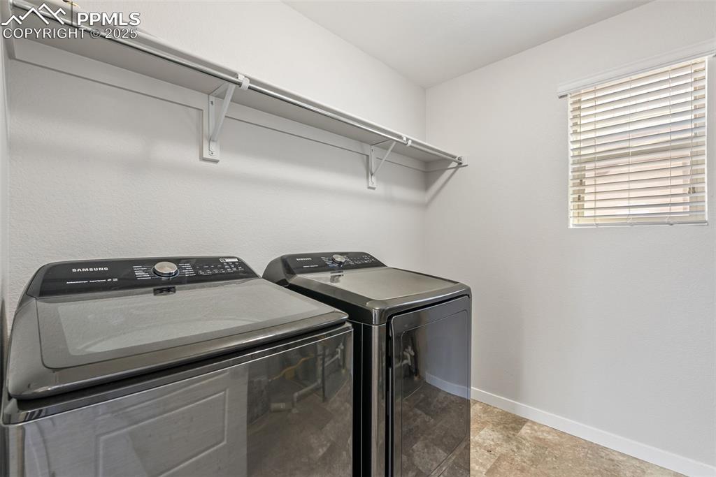 Image 27 of 50: Washroom with baseboards and independent washer and dryer