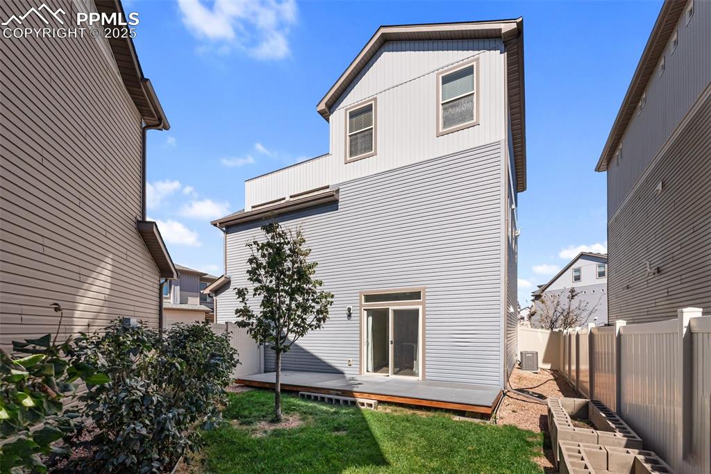 Image 40 of 50: Rear view of house with a wooden deck and a fenced backyard
