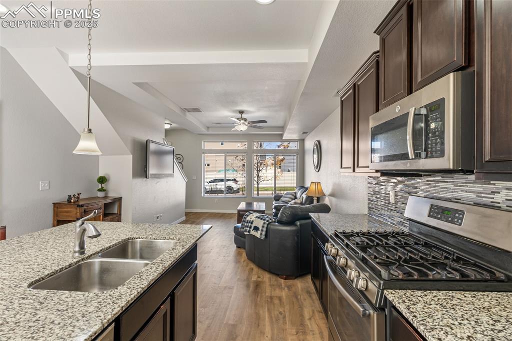 Image 5 of 50: Kitchen with appliances with stainless steel finishes, a tray ceiling, dark