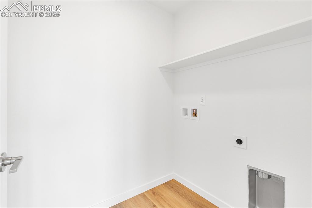 Image 20 of 39: Washroom featuring light wood-style floors, hookup for a washing machine, a