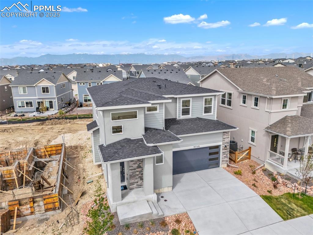Image 36 of 39: View of front of home featuring a residential view, stone siding, and roof 