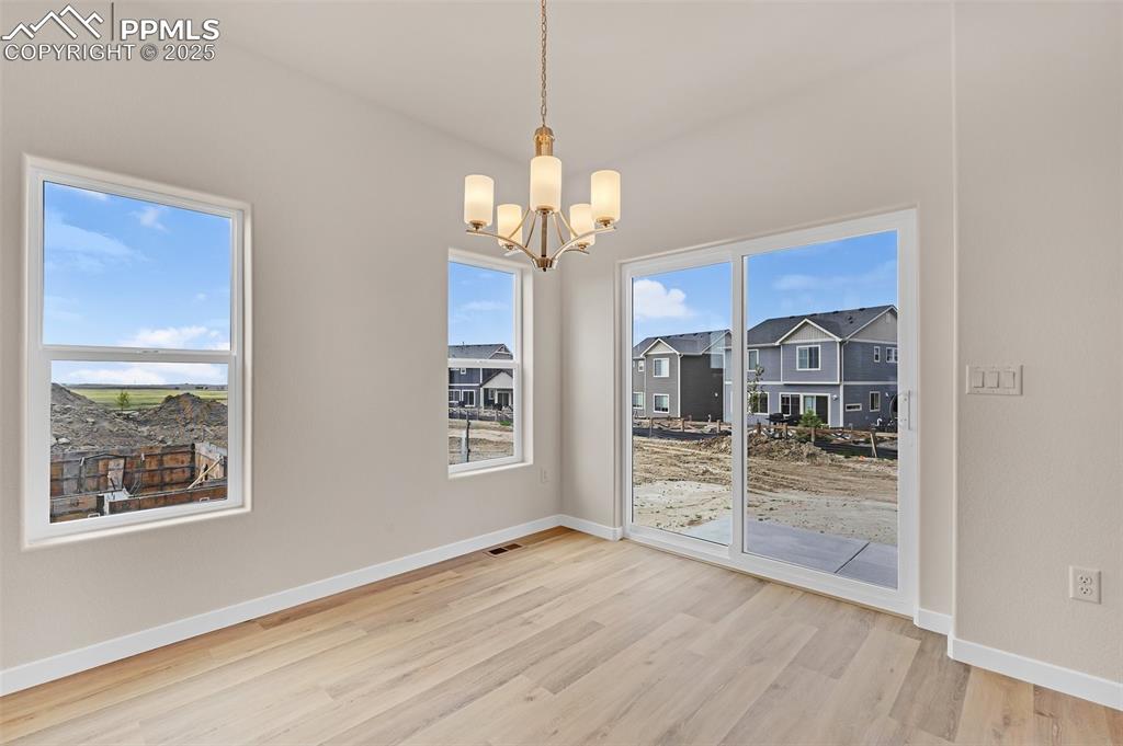 Image 6 of 39: Unfurnished dining area featuring light wood finished floors and a chandeli