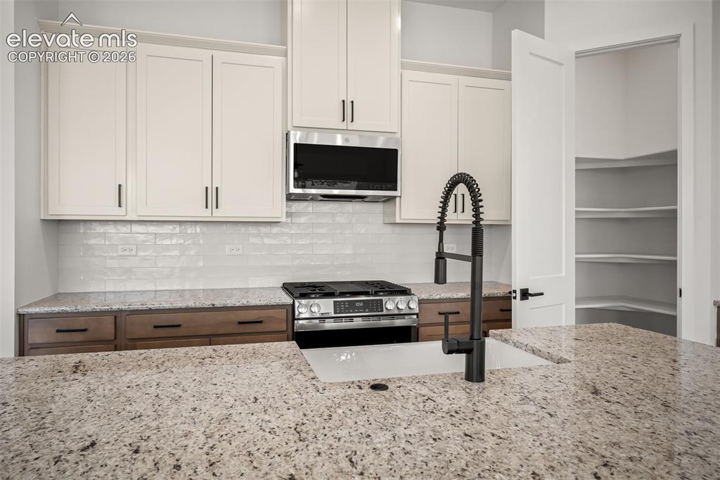 Image 10 of 45: Gourmet kitchen featuring granite countertops, a stainless steel gas range,