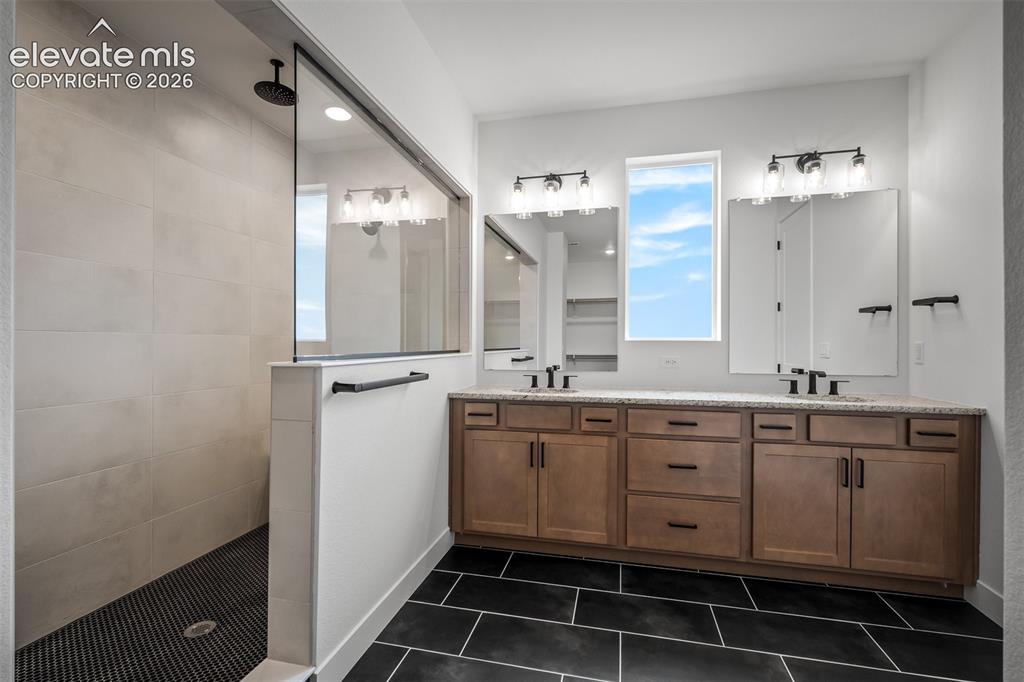 Image 25 of 45: Contemporary bathroom featuring a spacious walk-in shower with light-toned 