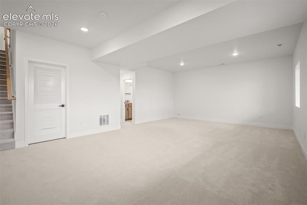 Image 35 of 45: Spacious finished basement with light-colored carpeting, neutral wall tones