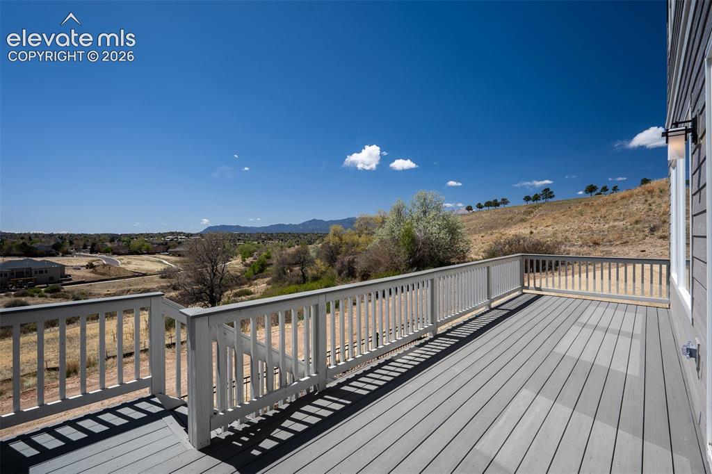 Image 42 of 45: Spacious outdoor deck featuring composite decking and white railing, provid