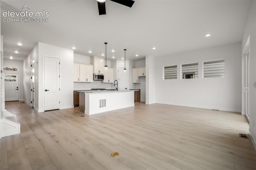 Image 6 of 45: Open-concept living space featuring light wood-finished flooring and a livi