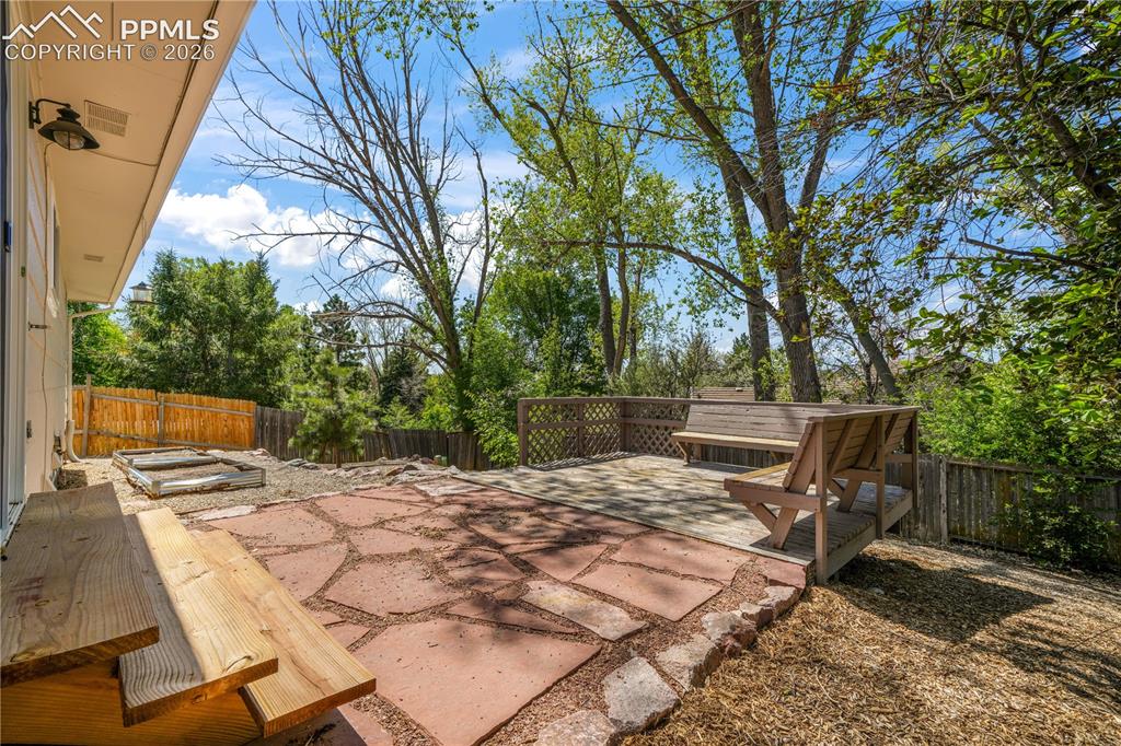Image 45 of 50: Back yard patio and deck with privacy fence