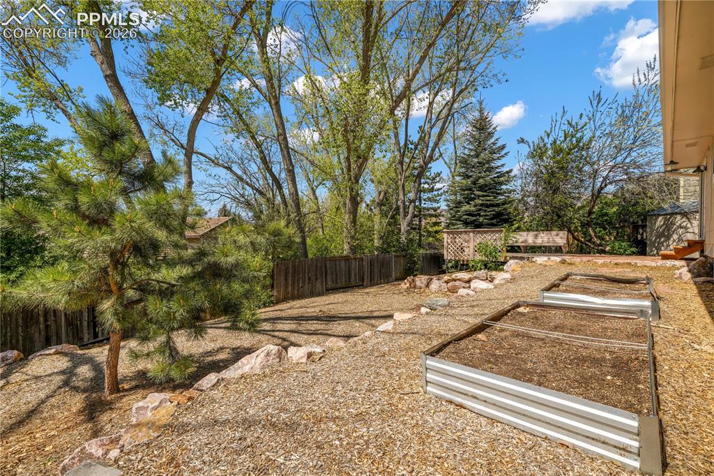 Image 46 of 50: Back yard patio and deck with privacy fence