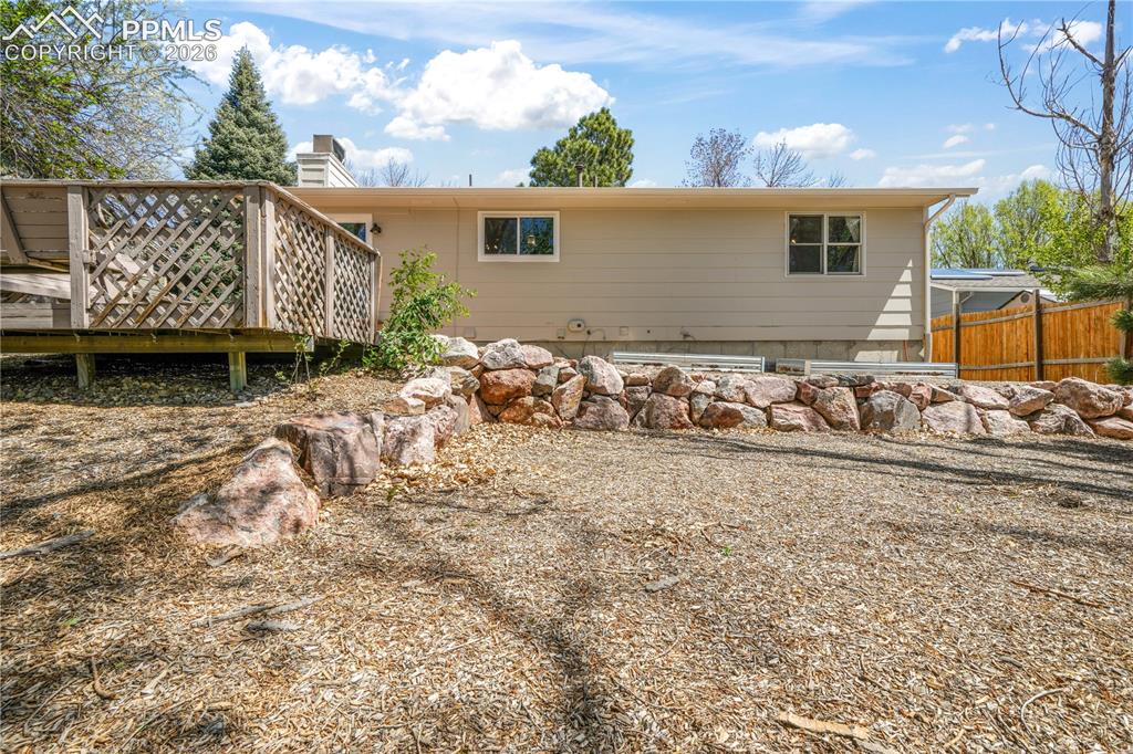 Image 48 of 50: Back yard patio and deck with privacy fence