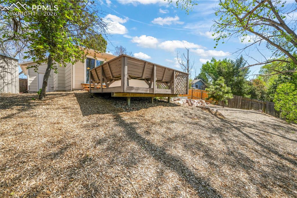 Image 49 of 50: Back yard patio and deck with privacy fence