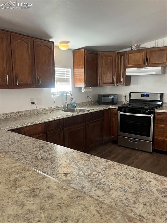 Image 3 of 11: Kitchen featuring dark wood finished floors, ventilation hood, range, and a
