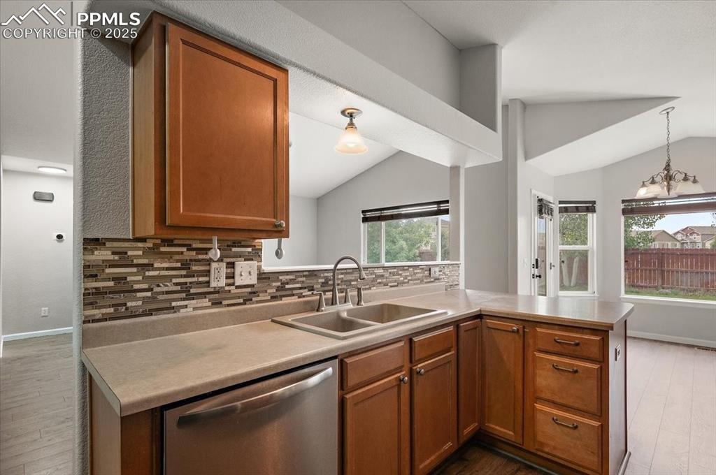 Image 11 of 35: Kitchen featuring lofted ceiling, dark wood-type flooring, dishwasher, back