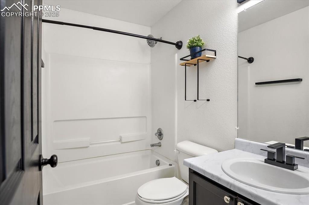 Image 17 of 35: Full bathroom featuring vanity, washtub / shower combination, and a texture
