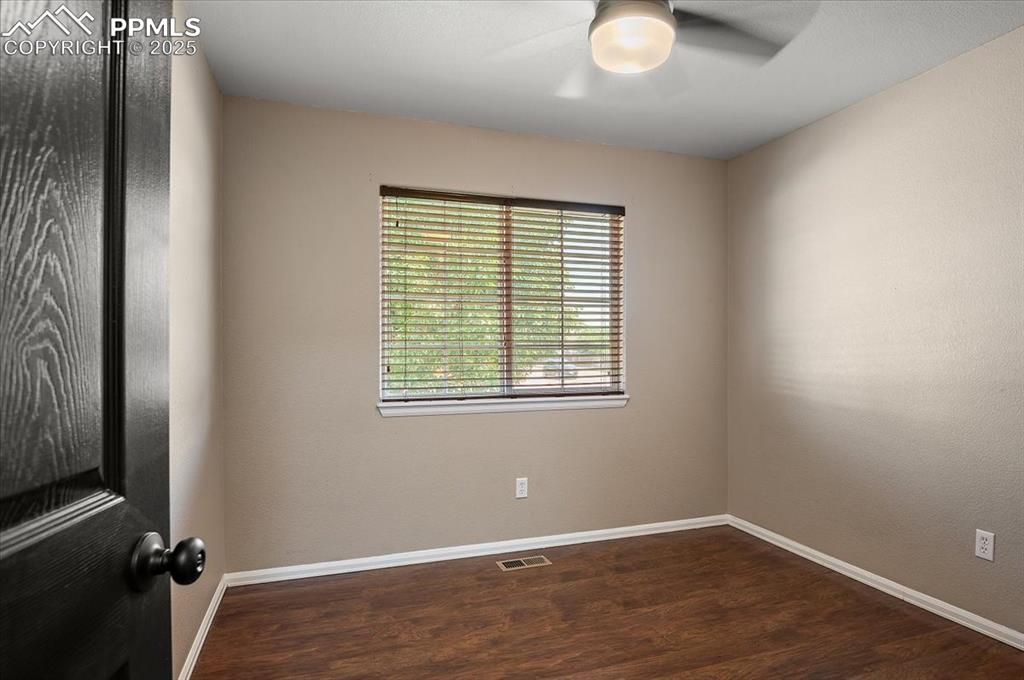 Image 18 of 35: Spare room featuring dark wood-style flooring and ceiling fan