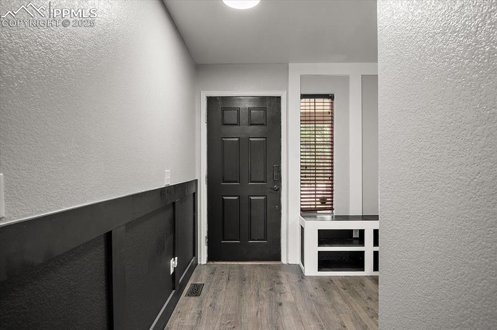 Image 19 of 35: Foyer entrance with a textured wall and wood finished floors