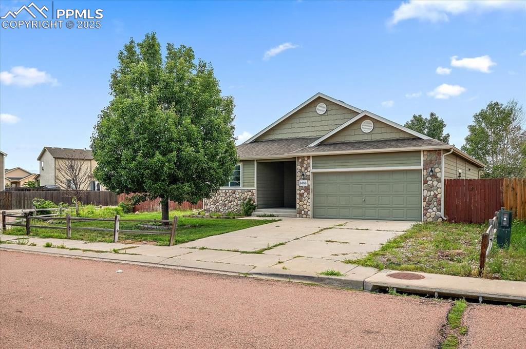 Image 2 of 35: View of front of property featuring stone siding, concrete driveway, a gara