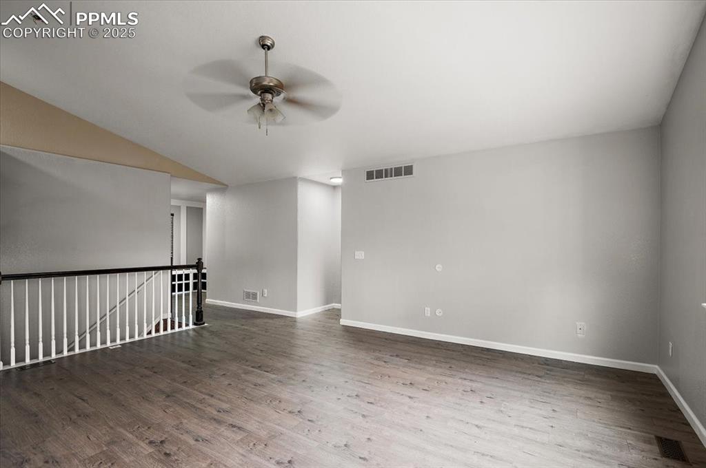 Image 24 of 35: Unfurnished room with a ceiling fan, wood finished floors, and vaulted ceil