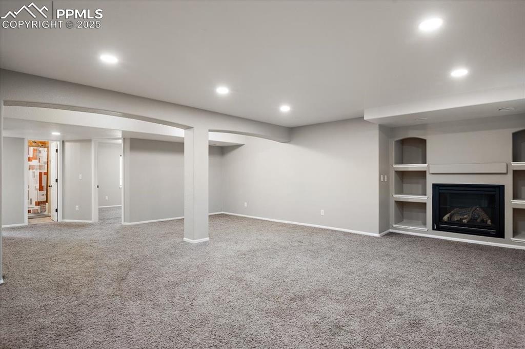 Image 30 of 35: Unfurnished living room featuring recessed lighting, carpet floors, built i