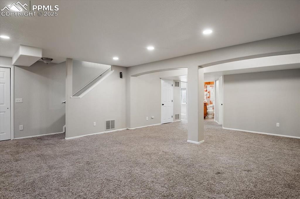 Image 32 of 35: Finished below grade area with recessed lighting, carpet flooring, and stai