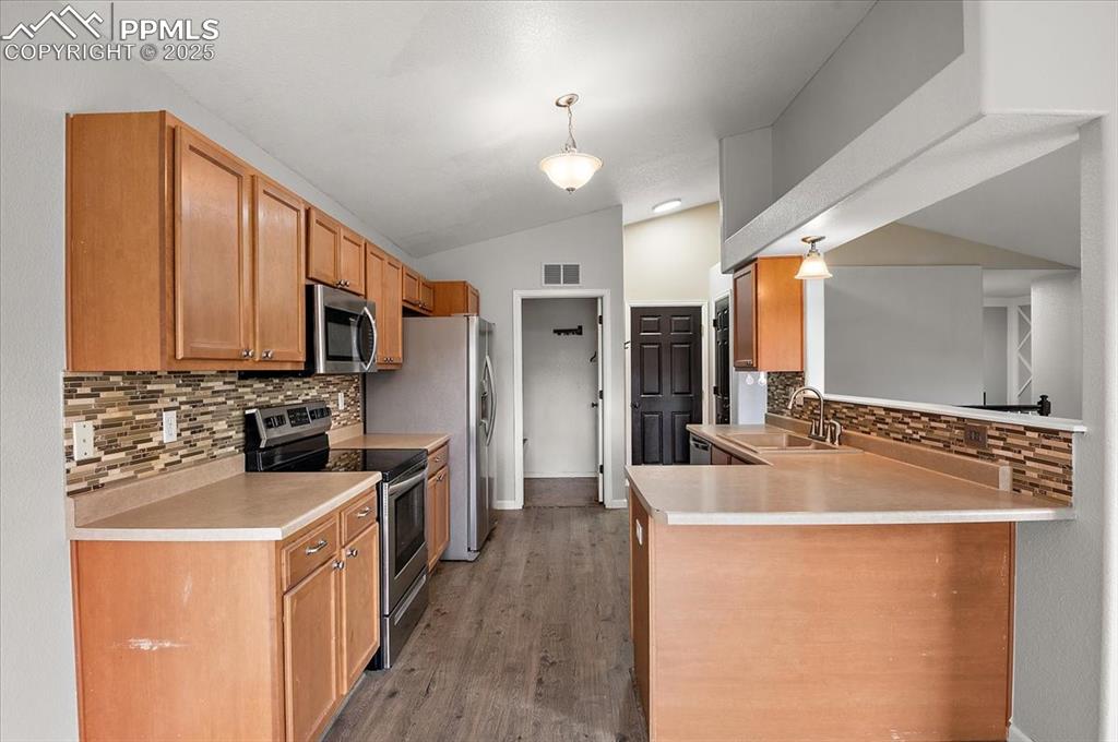 Image 8 of 35: Kitchen featuring decorative backsplash, appliances with stainless steel fi