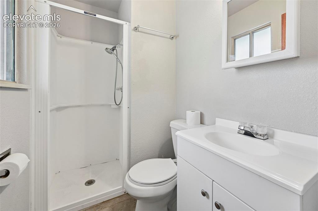 Image 15 of 29: Bathroom featuring a stand-up shower, white vanity with integrated sink, ch