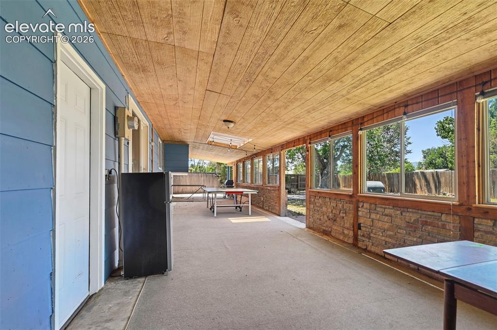 Image 16 of 29: Covered patio featuring a wood-finish ceiling, blue siding, a concrete floo