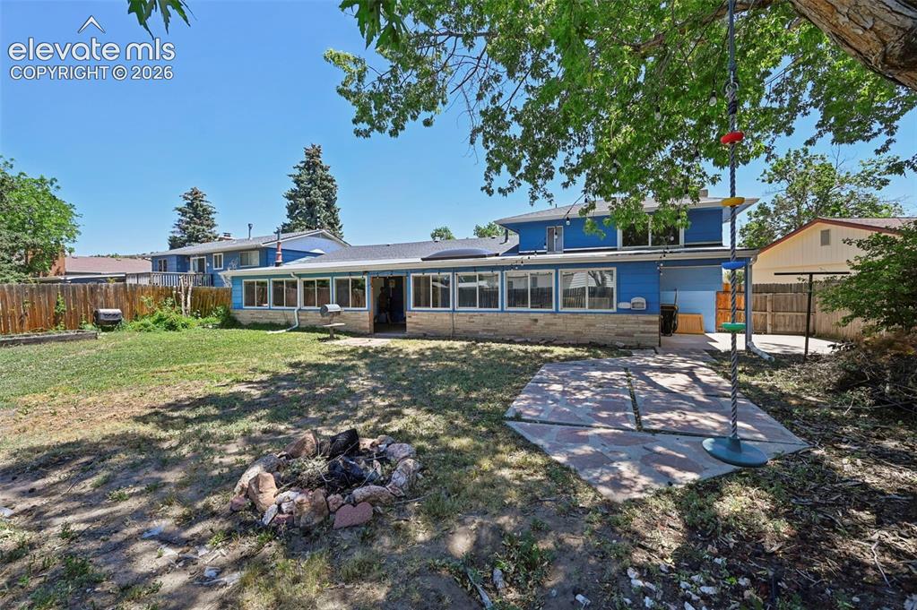 Image 17 of 29: Expansive backyard featuring a stone-lined fire pit, a paved patio area, an