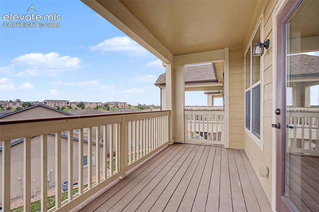 Image 17 of 23: Expansive covered balcony featuring composite decking, white spindle railin