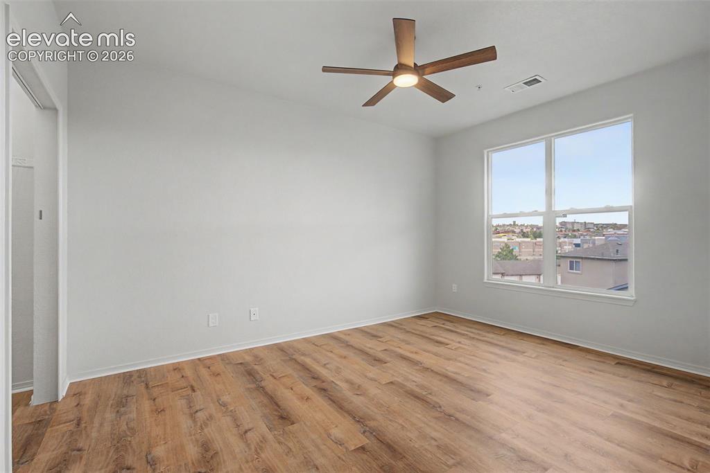 Image 19 of 23: Bright interior space featuring wood-finish flooring, a large window, a cei