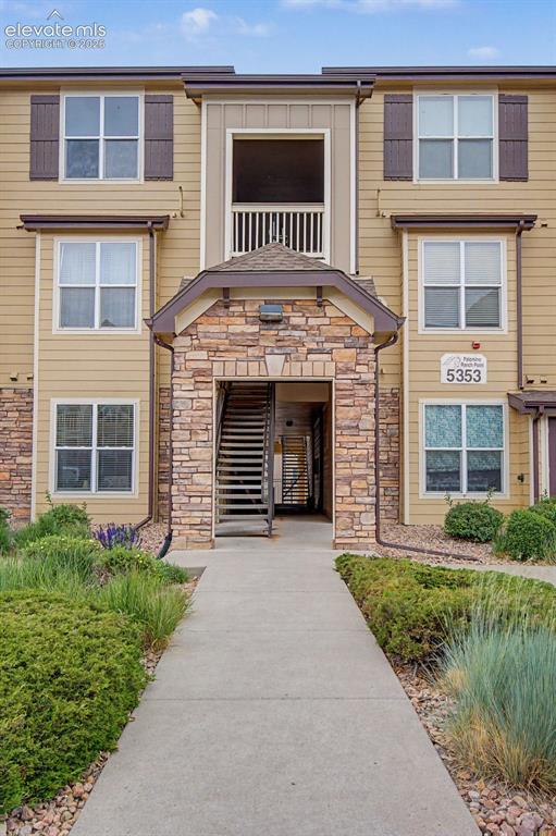 Image 2 of 23: Multi-story building exterior featuring stone veneer accents