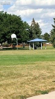 Image 47 of 50: Expansive green space featuring a basketball hoop, covered picnic area, and