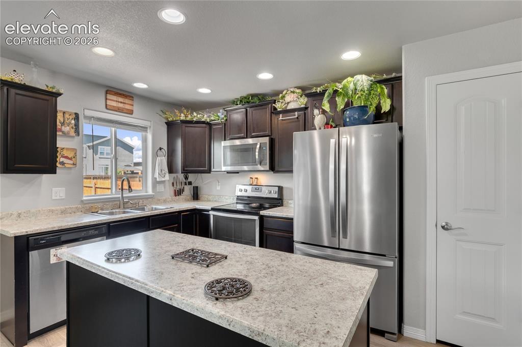 Image 13 of 38: Kitchen featuring an L-shaped counter, a center island, recessed lighting,