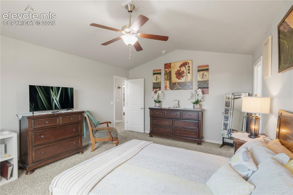 Image 20 of 38: Tray ceiling with a ceiling fan, light-colored carpeting, and a white inter