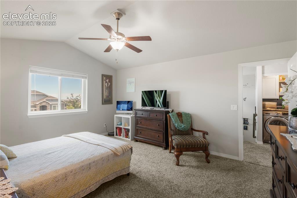 Image 21 of 38: Vaulted ceiling with a ceiling fan, carpeted flooring, and a large window