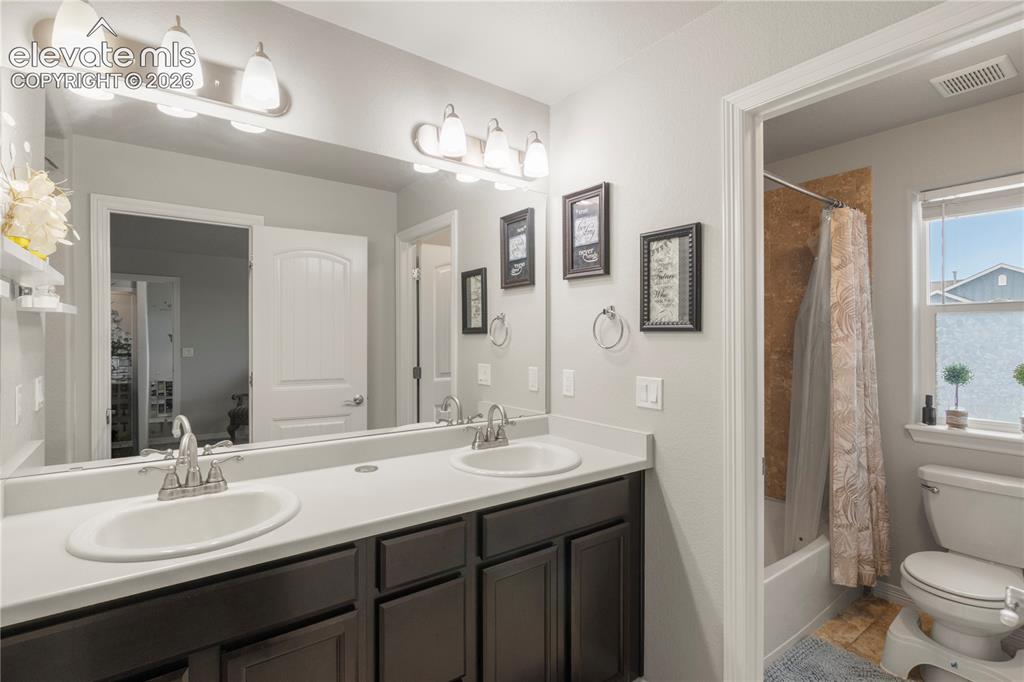 Image 22 of 38: Dual vanity with integrated sinks and dark wood-finish cabinetry