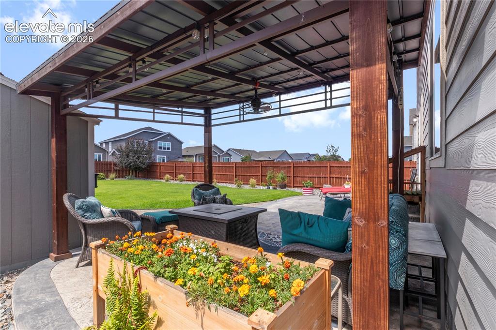 Image 33 of 38: Metal-roofed patio cover with wood posts, concrete patio, and fenced yard