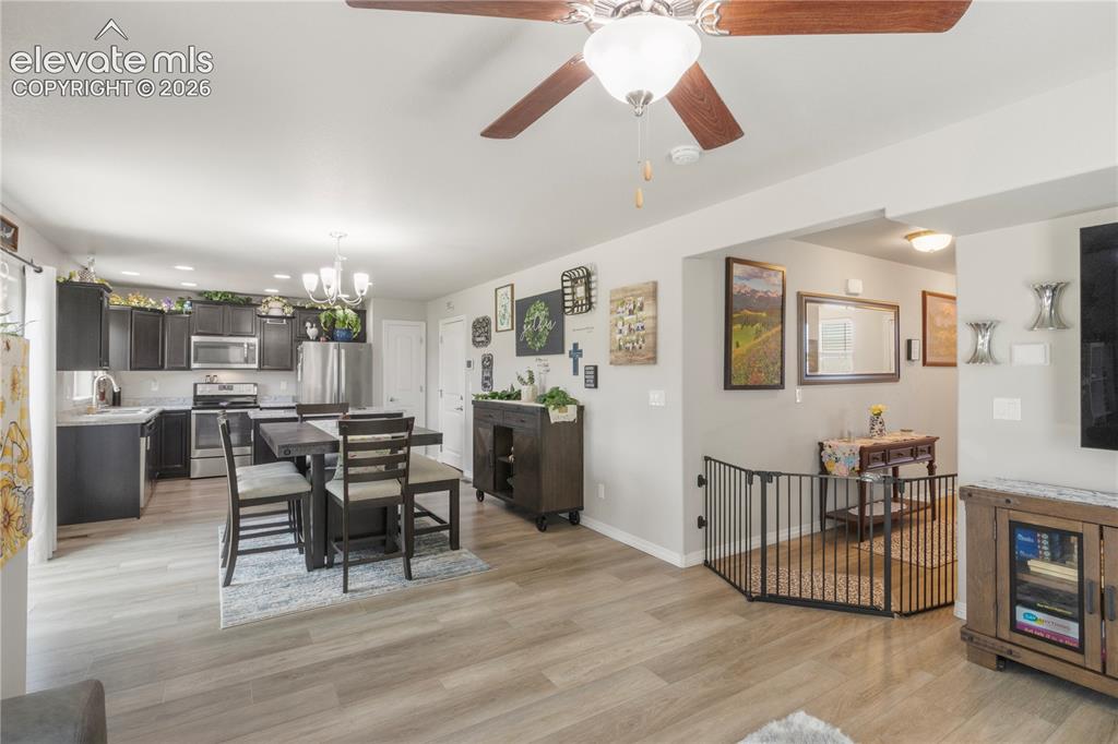 Image 5 of 38: Open-concept living space with wood-finish flooring, a contemporary ceiling