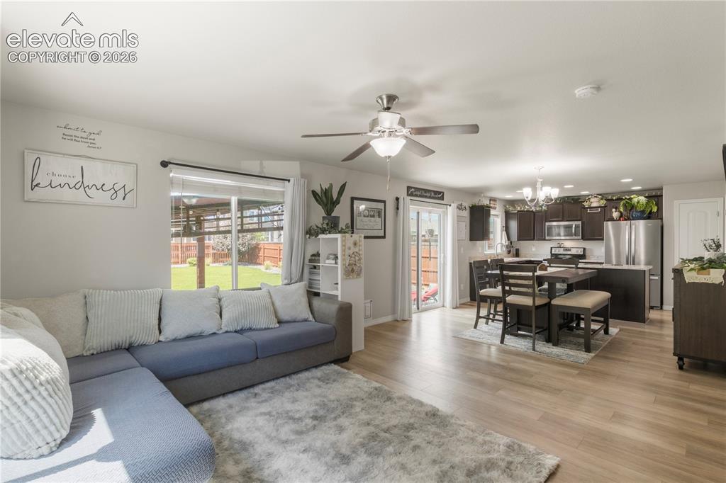 Image 8 of 38: Open-concept living space featuring wood-finish flooring, a ceiling fan wit