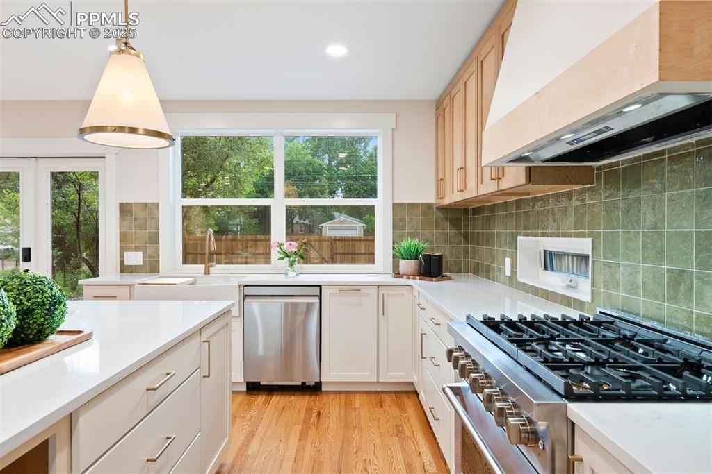 Image 10 of 39: 6 burner gas range and views out the back yard from the kitchen sink.