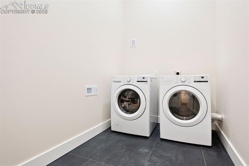Image 25 of 39: Main level laundry room with heated slate tile floors.