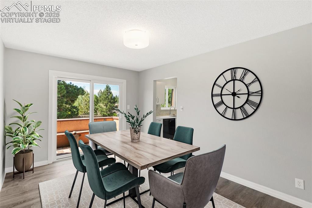Image 11 of 48: Virtually Staged - Dining area with light wood-type flooring and a textured